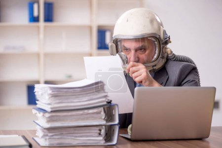 Photo for Old employee wearing spacesuit in the office - Royalty Free Image