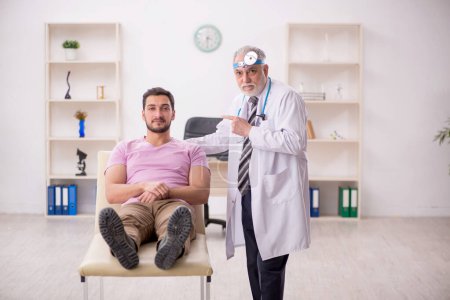 Photo for Young patient visiting old doctor otologist - Royalty Free Image