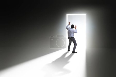 Foto de Empresario entrando puerta retroiluminada en el concepto de escape - Imagen libre de derechos