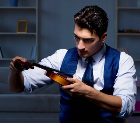 Photo for The young musician man practicing playing violin at home - Royalty Free Image