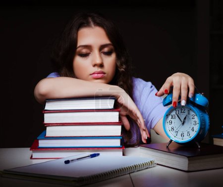Téléchargez les photos : La jeune étudiante se prépare aux examens tard à la maison - en image libre de droit
