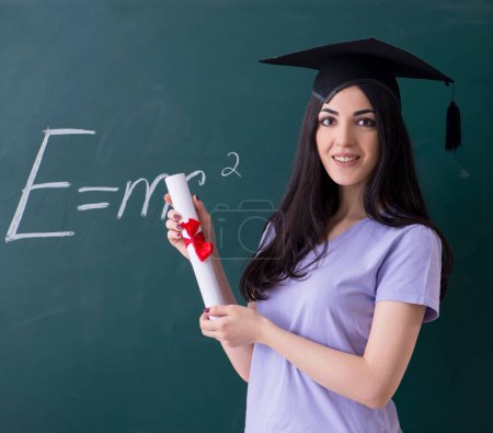 Téléchargez les photos : The female graduate student in front of green board - en image libre de droit
