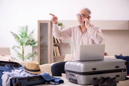 Photo for Aged man preparing for trip at home - Royalty Free Image