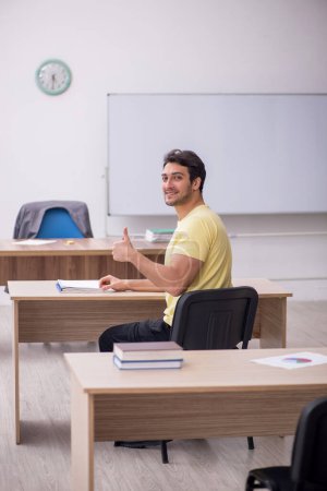 Téléchargez les photos : Young student teacher sitting in the classroom - en image libre de droit