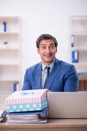 Photo for Young businessman employee celebrating birthday at workplace - Royalty Free Image