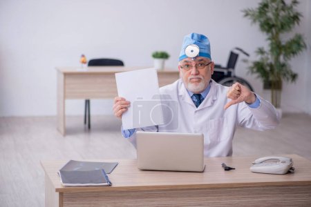 Photo for Old docror otolaryngologist working at the hospital - Royalty Free Image