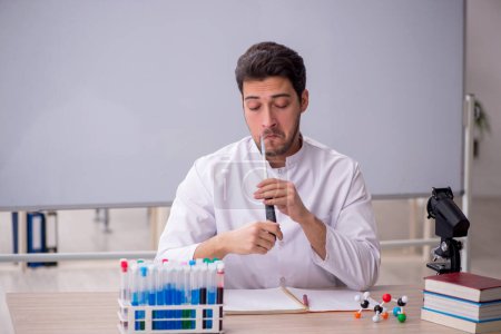 Photo for Young chemist teacher sitting in the classroom - Royalty Free Image