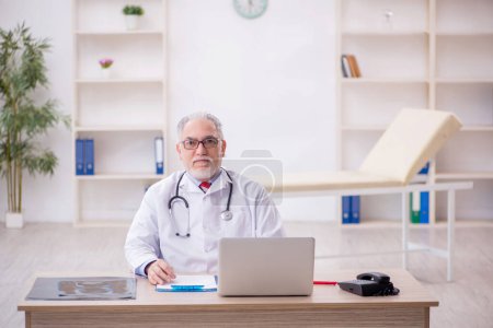 Téléchargez les photos : Vieux médecin travaillant à l'hôpital - en image libre de droit