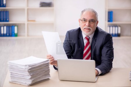 Téléchargez les photos : Vieil employé et trop de travail au bureau - en image libre de droit