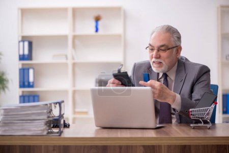 Téléchargez les photos : Vieil homme d'affaires employé dans le concept e-commerce - en image libre de droit