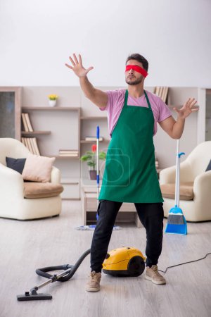 Téléchargez les photos : Jeune entrepreneur les yeux bandés nettoyer la maison - en image libre de droit