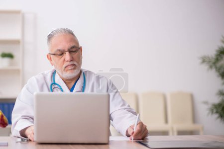 Photo for Old doctor working at the hospital - Royalty Free Image