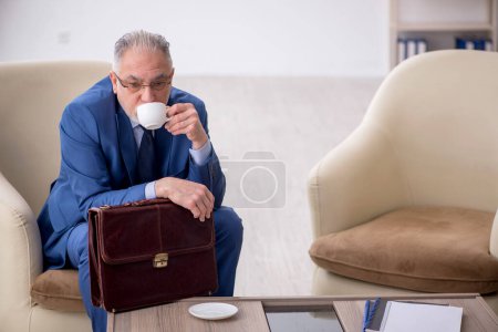 Foto de Viejo jefe masculino esperando una reunión de negocios - Imagen libre de derechos