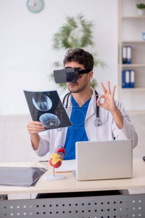 Foto de Joven médico disfrutando de gafas virtuales en la clínica - Imagen libre de derechos