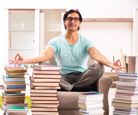Photo for The male student with many books at home - Royalty Free Image