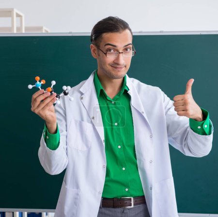 Foto de El joven profesor de química frente a la pizarra - Imagen libre de derechos