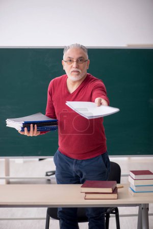 Foto de Old teacher sitting in the classroom - Imagen libre de derechos