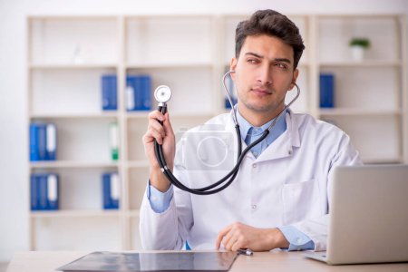 Photo for Young doctor holding stethoscope in the clinic - Royalty Free Image