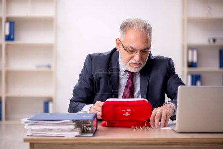 Foto de Viejo empleado de negocios sintiéndose mal en la oficina - Imagen libre de derechos