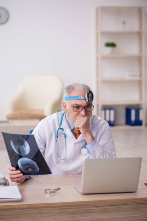 Photo for Old doctor otologist working at the hospital - Royalty Free Image