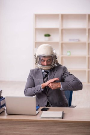 Foto de Young businessman employee wearing spacesuit at workplace - Imagen libre de derechos