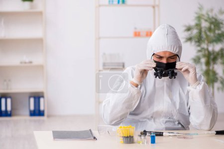 Téléchargez les photos : Jeune chimiste travaillant au laboratoire pendant la pandémie - en image libre de droit