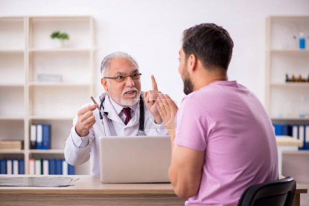 Photo for Young patient visiting old male doctor - Royalty Free Image