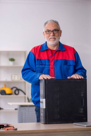 Photo for Old repairman repairing computer at the lab - Royalty Free Image