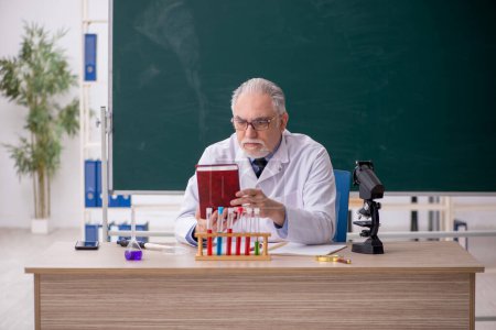 Foto de Old chemist teacher sitting in the classroom - Imagen libre de derechos