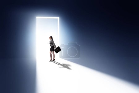 Foto de Mujer de negocios entrando puerta retroiluminada en el concepto de escape - Imagen libre de derechos