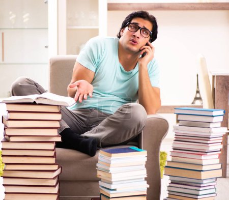 Téléchargez les photos : The male student with many books at home - en image libre de droit
