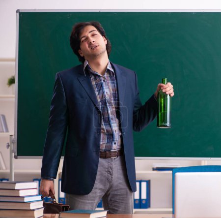 Téléchargez les photos : Le professeur mâle buvant dans la classe - en image libre de droit