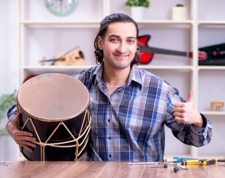 Téléchargez les photos : Le jeune beau réparateur réparateur tambour - en image libre de droit