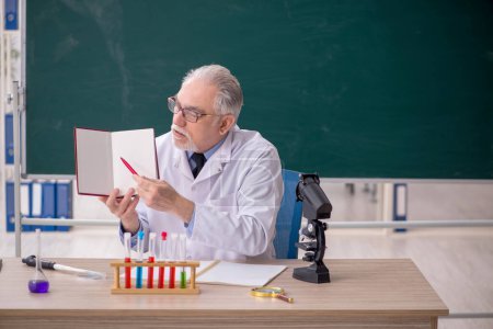 Foto de Old chemist teacher sitting in the classroom - Imagen libre de derechos