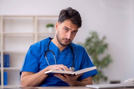 Photo for Young doctor student reading the book - Royalty Free Image