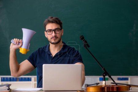 Photo for Young music teacher holding megaphone in the classroom - Royalty Free Image