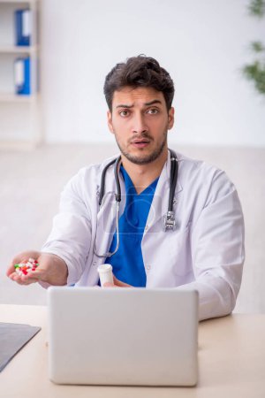 Photo for Young doctor suggesting pills in the clinic - Royalty Free Image