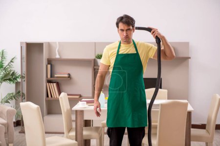 Téléchargez les photos : Jeune homme nettoyer la maison - en image libre de droit
