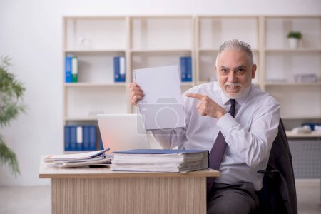 Téléchargez les photos : Ancien employé travaillant dans le bureau - en image libre de droit