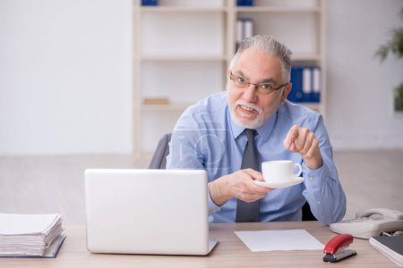 Foto de Viejo empleado bebiendo café durante el descanso - Imagen libre de derechos