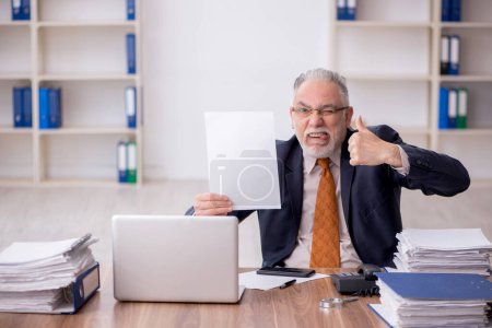 Téléchargez les photos : Old employee working at workplace - en image libre de droit