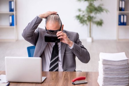 Foto de Viejo empleado disfrutando de gafas virtuales en el lugar de trabajo - Imagen libre de derechos