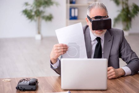 Photo for Old employee enjoying virtual glasses at workplace - Royalty Free Image