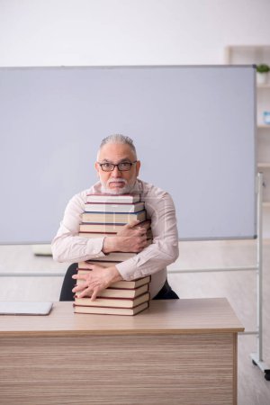Foto de Old teacher sitting in the classroom - Imagen libre de derechos