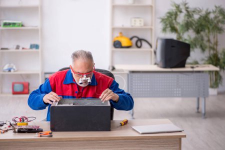 Photo for Old repairman repairing computer at the lab - Royalty Free Image