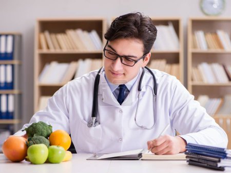 Foto de El médico en concepto de dieta con frutas y verduras - Imagen libre de derechos