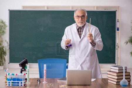 Foto de Old teacher chemist sitting in the classroom - Imagen libre de derechos
