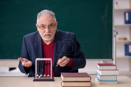 Photo for Old teacher physicist sitting in the classroom - Royalty Free Image