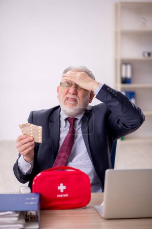 Téléchargez les photos : Vieil homme d'affaires employé se sentant mal dans le bureau - en image libre de droit