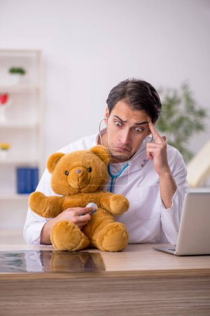 Photo for Young doctor holding toy bear - Royalty Free Image